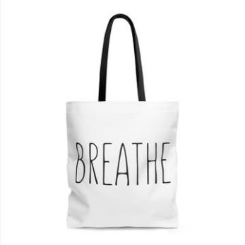 White tote with black handles and Breathe lettering